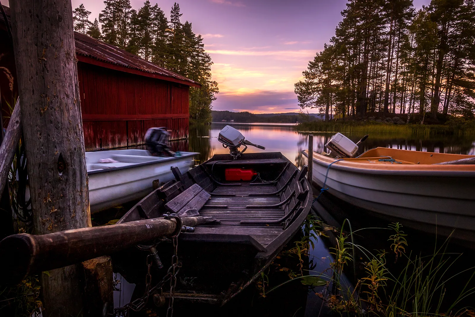 Röda sjöbodar på pelare i stilla vatten vid Gimmen.