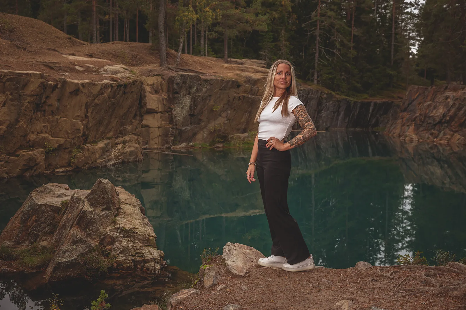 Turkost vatten i gruvbrott med speglade klippväggar vid Östra Silvberg.