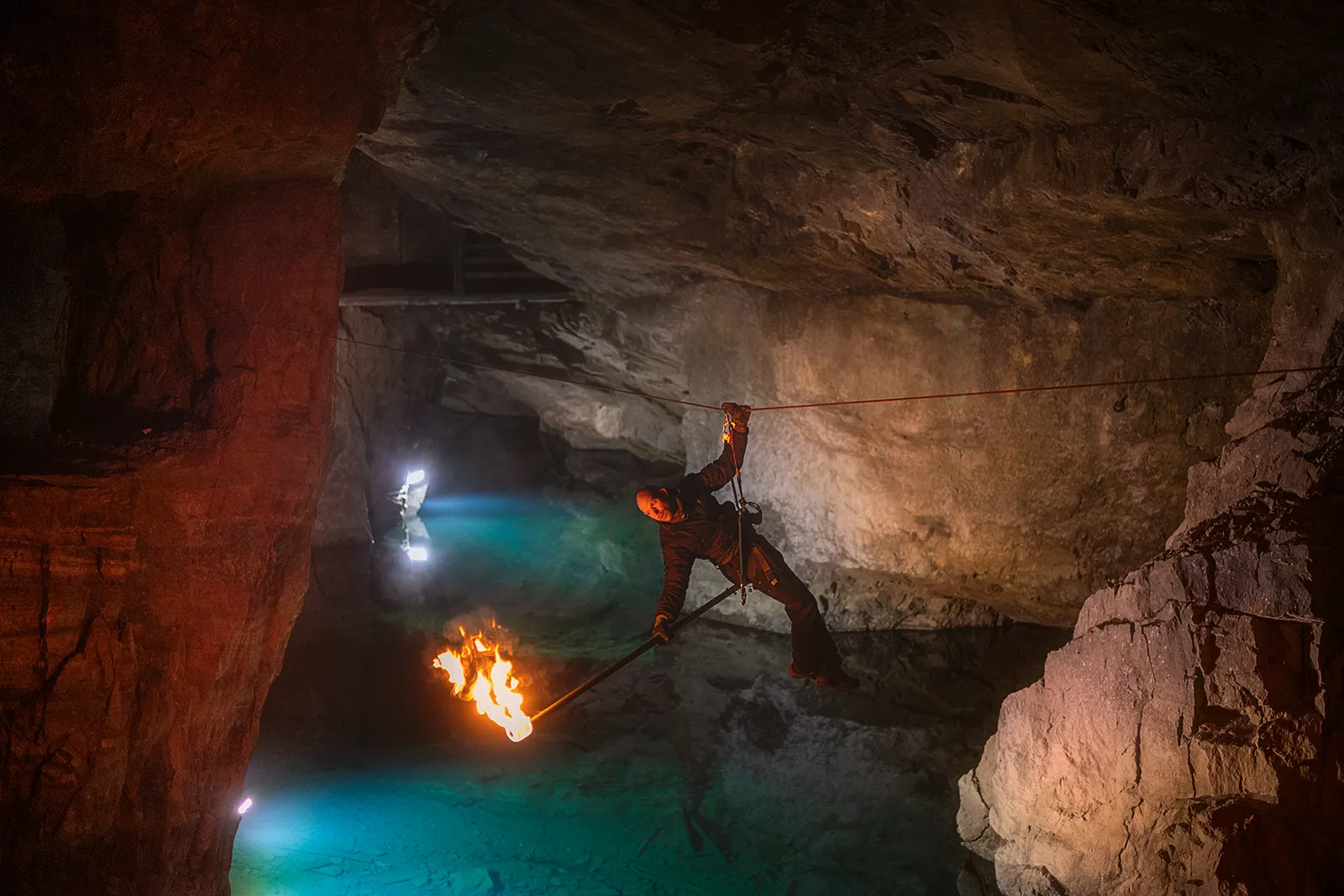 Man med fackla på zipline i Äventyrsgruvan
