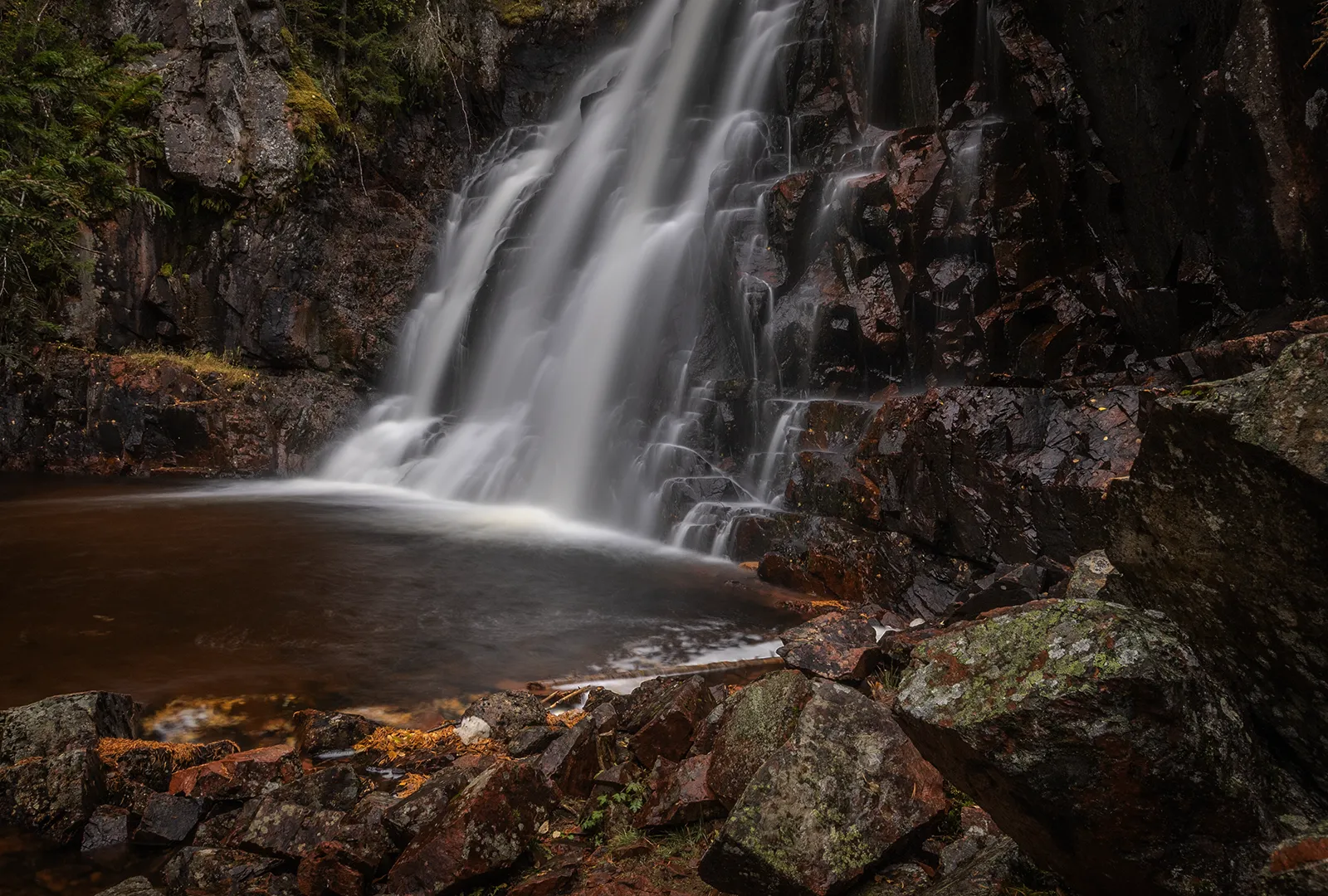 Närbild av Stopfallet där vatten rinner ner över klippor till en liten bassäng nedanför.